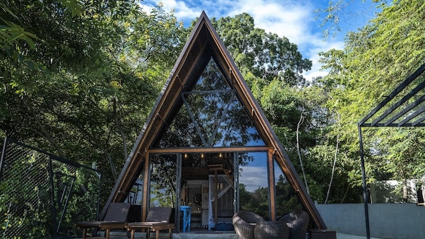 A triangular wooden structure with a pool in front. - Area 4 eco cubes (Ella)