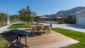A patio with a grill, a table and chairs, and a pool in the background. - Villa Evelyn with Private Pool (Αρχάγγελος)