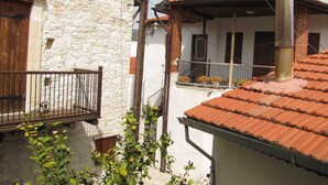 Un edificio in pietra dal design tradizionale con un balcone in legno e un tetto in tegole.