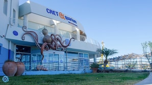 Um edifício com uma grande escultura de polvo na frente, identificado como 