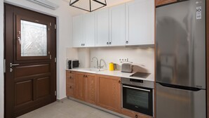 Een moderne keuken met houten kastjes, een roestvrijstalen koelkast, een magnetron, een broodrooster en een oven.