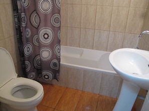 A bathroom with a toilet, a bathtub, and a sink.