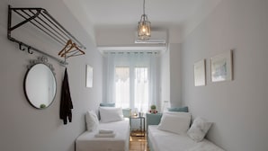 A bedroom with two beds, a hanging clothes rack, a mirror, and a window with curtains. - Attractive Flat near the Acropolis Museum - Athenian Homes, Athenian Homes (Athens)
