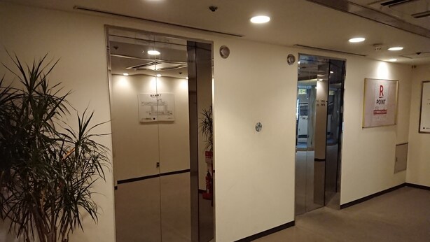A hallway with double doors, a fire extinguisher, and a plant. - Mihara Kokusai Hotel (Mihara)