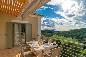 Een balkon met een ontbijtje gedekt, met uitzicht op een prachtig landschap.