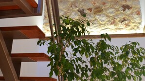 Eine Treppe mit Holzstufen und Metallgeländern, die zu einer Steinwand mit einem dekorativen Muster führt.