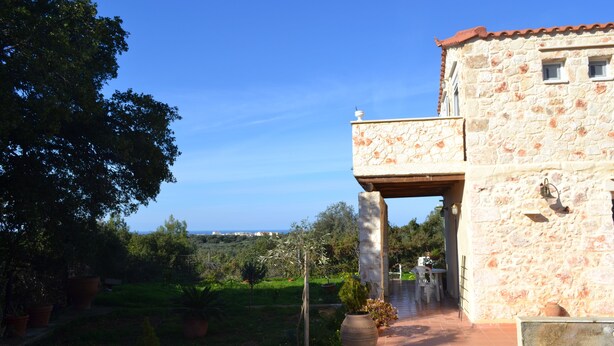 Ein Steinhaus mit Balkon, Garten und Meerblick.