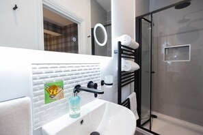 Shower, designer toiletries, hair dryer, towels