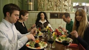 A group of people dining at a restaurant with a green wall and a decorative panel in the background. - Hotel Krokodil (Heidelberg)