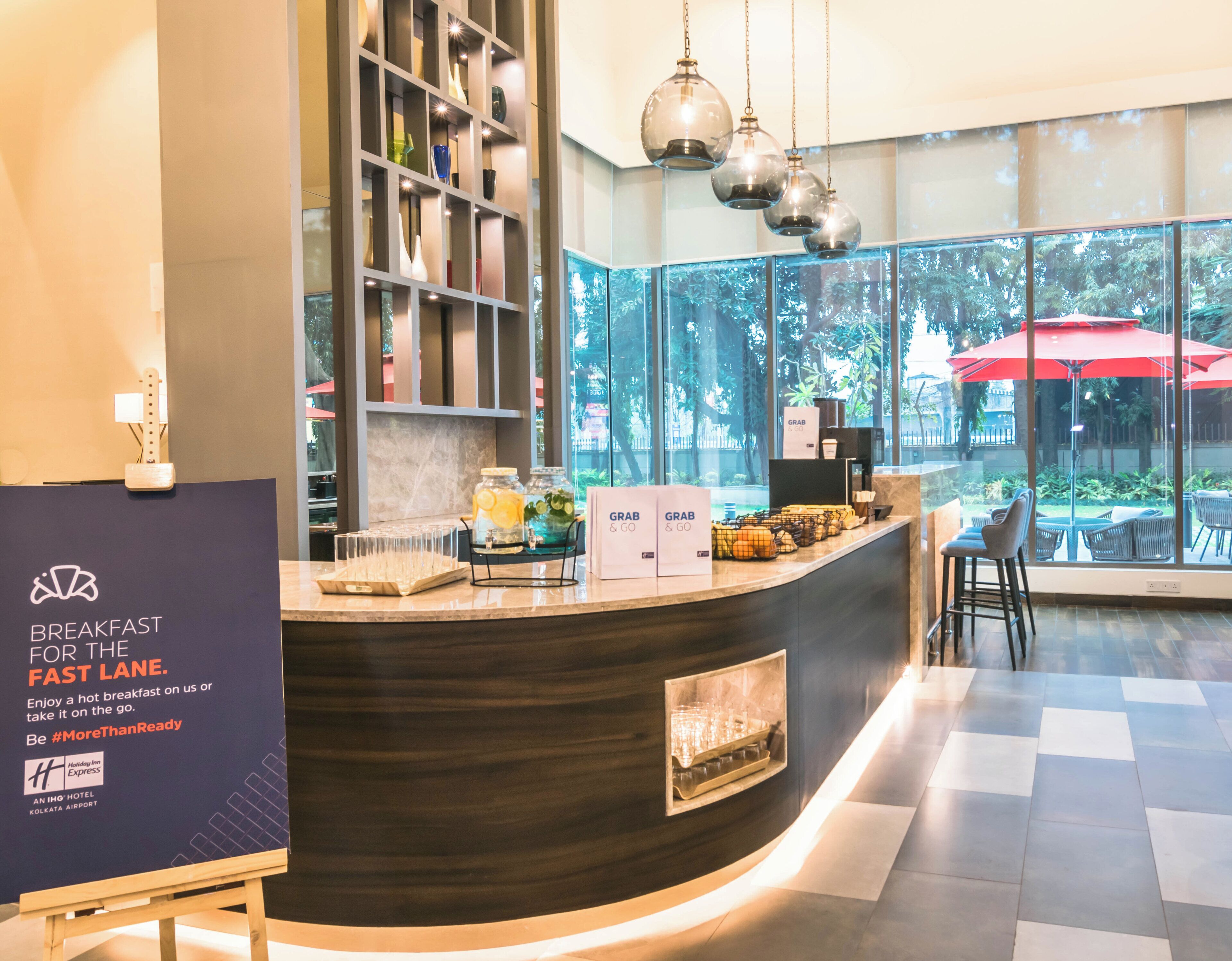 Un comptoir de petit-déjeuner dans un hôtel d’aéroport, avec une pancarte indiquant « Petit-déjeuner pour les voyageurs pressés ».
