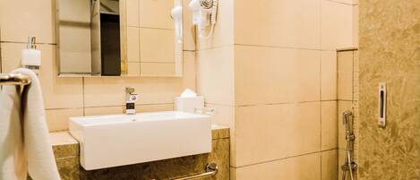 A bathroom with a sink, mirror, towel rack, and a shower.