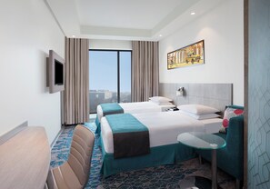 A hotel room with two beds, a TV, a small table, a sofa, and a large window with curtains. - Holiday Inn Express Kolkata Airport by IHG (Barakpur)