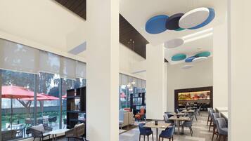 A modern interior with large windows, a dining area, and a bar.