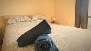 A hotel room with a bed, pillows, a lamp, and a window. - Harley Serviced Apartments - West Point (Sheffield)