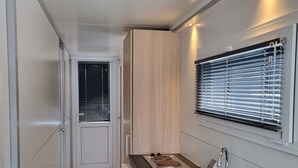 A modern kitchen with a built-in stove, a sink, and a window with blinds. - Houseboat Havana (Amsterdam)