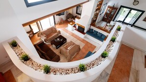 A spacious living area with a curved white bench, a fireplace, and a dining area with a table and chairs.