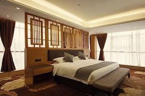 A modern hotel room with a large bed, a wooden headboard, and a bench at the foot of the bed. - Days Inn by Wyndham Yongan (Sanming)