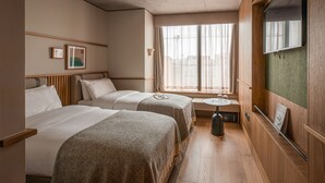 A hotel room with two beds, a small table, a mirror, and a window with curtains. - Wren Urban Nest (Dublin)