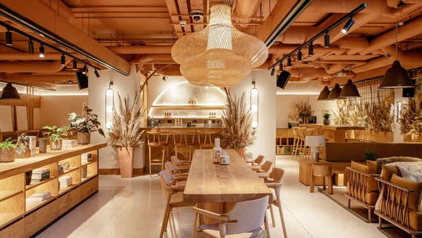 A spacious dining area with a long wooden table, surrounded by chairs, and a central hanging light fixture. - Wren Urban Nest (Dublin)