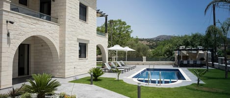 Alberca al aire libre y camastros