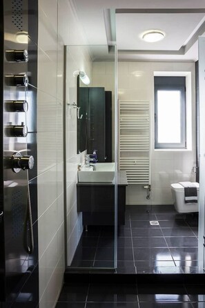 A modern bathroom with a glass shower enclosure, a white sink, a mirror, and a toilet. - Villa 200m to Beach & Amenities w/Pool, Sauna, BBQ (Αλμυρίδα)