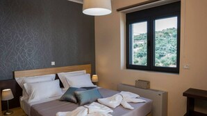 A neatly made bed with pillows, a bedside lamp, and a window with a view of greenery. - Villa 200m to Beach & Amenities w/Pool, Sauna, BBQ (Αλμυρίδα)