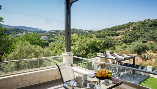 A balcony with a clear view of a hilly landscape, a table with a fruit bowl, and a chair. - Villa 200m to Beach & Amenities w/Pool, Sauna, BBQ (Αλμυρίδα)
