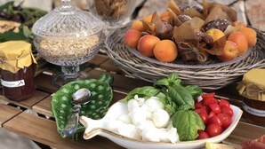 Una mesa con diversos alimentos, entre ellos frutas, verduras y salsas.