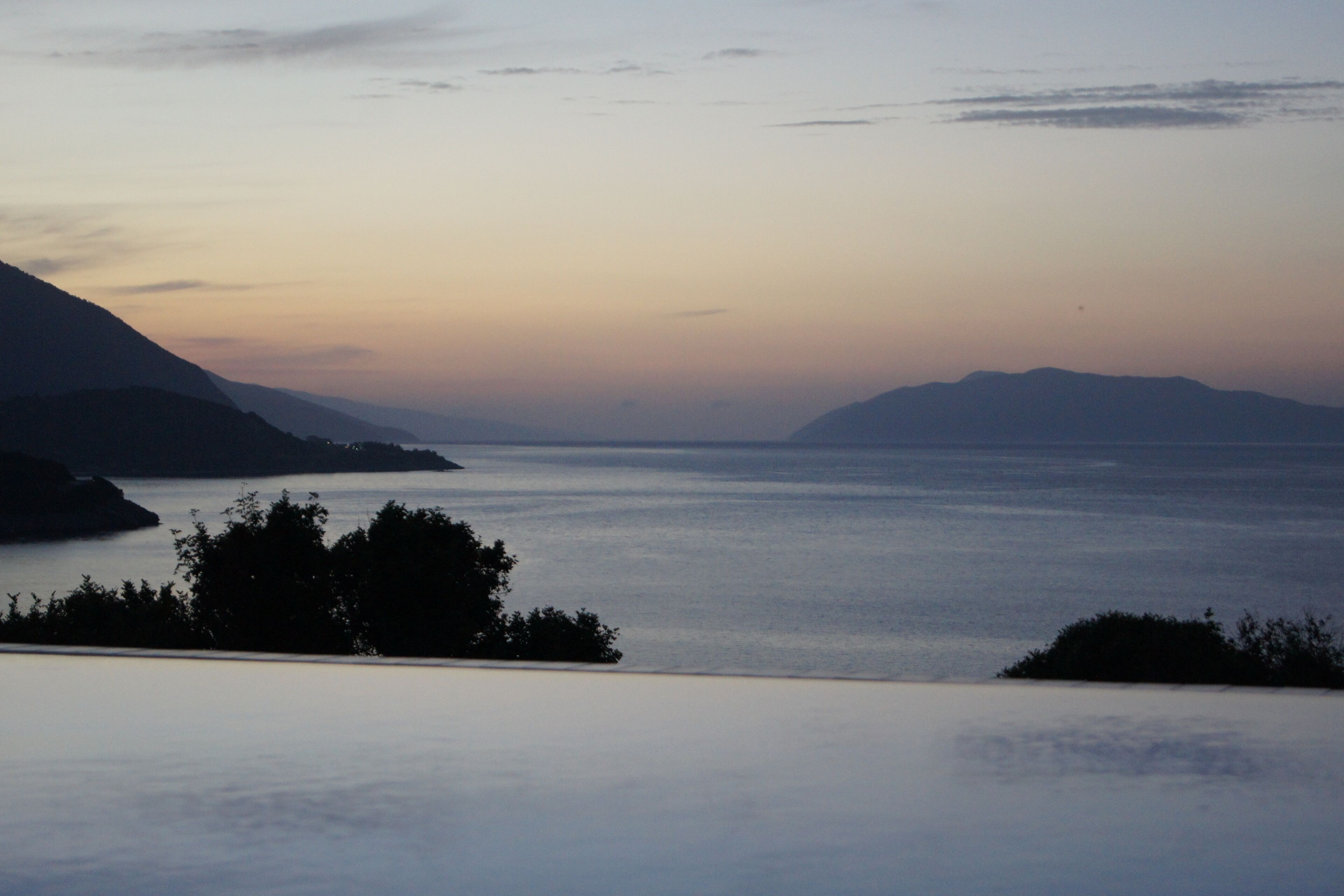 A coastal landscape with mountains and a calm sea.