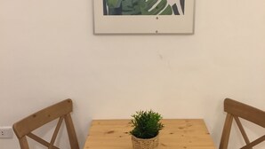 A wooden table with a small potted plant in the center, flanked by two wooden chairs.