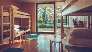 L’intérieur d’un chalet accueillant, avec des lits superposés, une petite table et une vue sur l’extérieur.