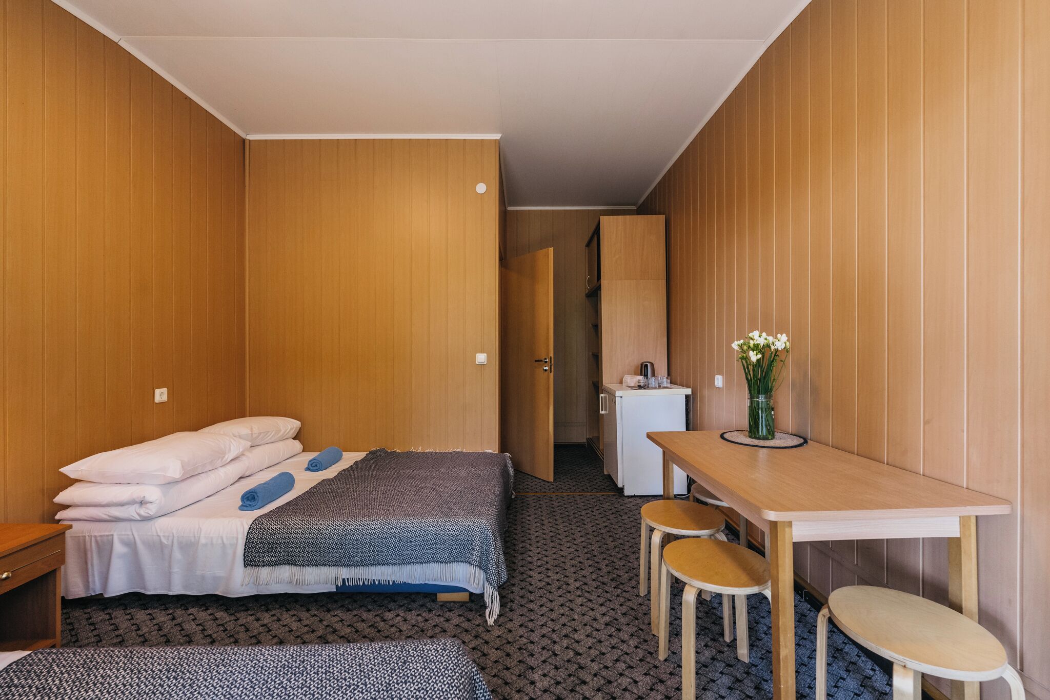 A compact hotel room with a bed, a small desk, and a chair.