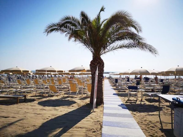Plage privée, sable blanc, parasols, serviettes de plage