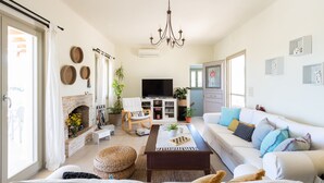 Una sala de estar amplia con chimenea, televisor, sofá y mesa de centro.
