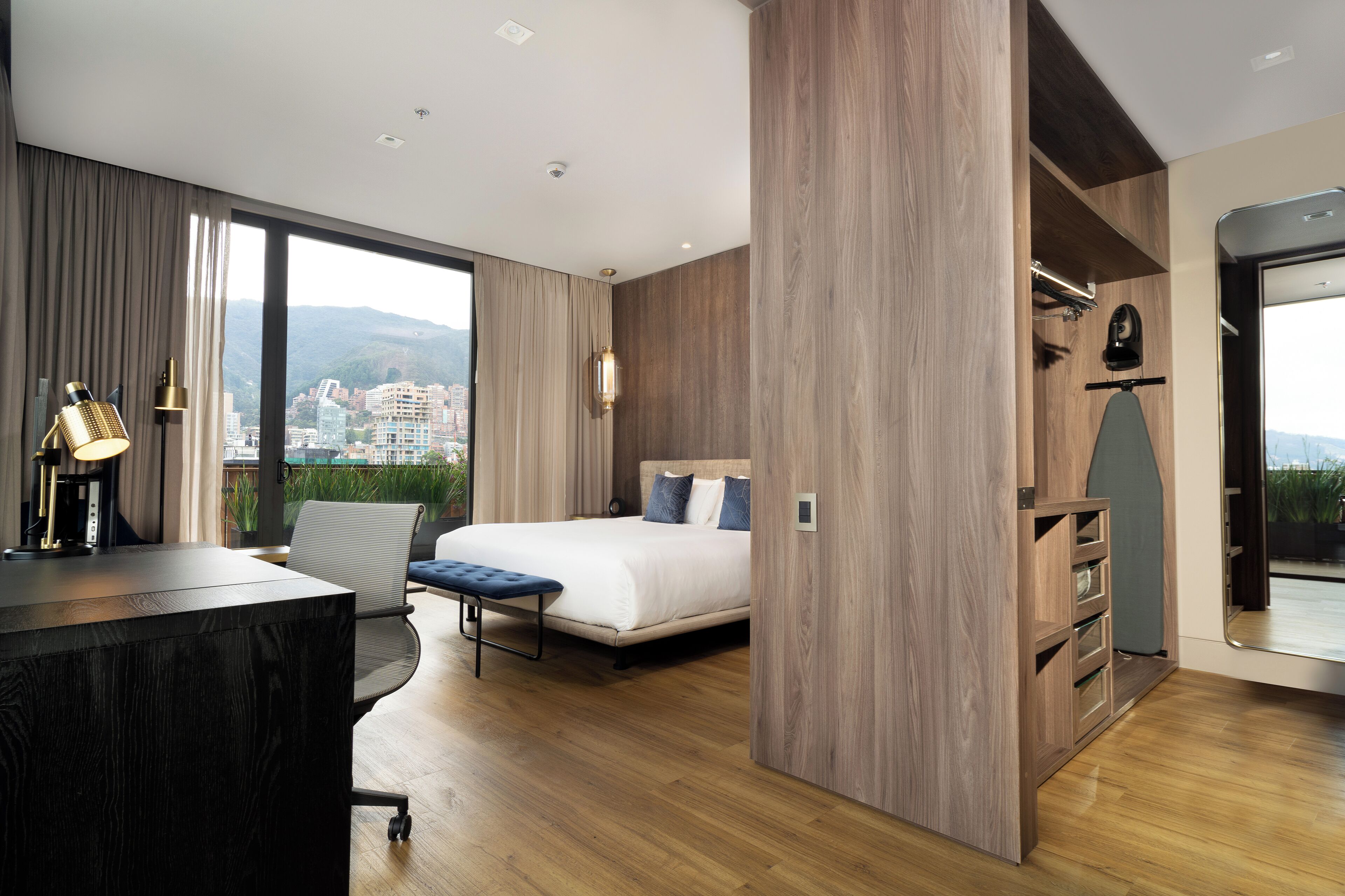 Une chambre d’hôtel moderne avec un grand lit, un bureau et une vue sur la ville.