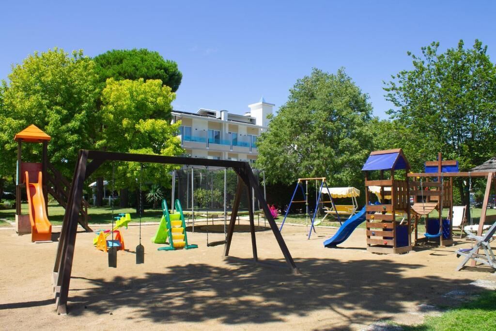 Une aire de jeux dotée de diverses installations, notamment des balançoires, des toboggans et des structures d’escalade.