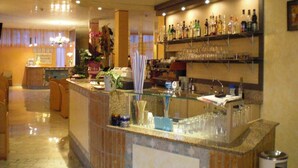 Eine Hotelhalle mit Barbereich, ausgestattet mit einer Marmorplatte, Gläsern und verschiedenen Flaschen.