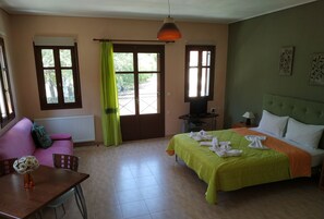 Habitació amb llit, sofà, taula i televisió.