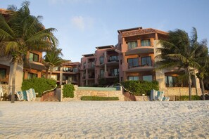 En la playa, arena blanca, sillas reclinables de playa, sombrillas