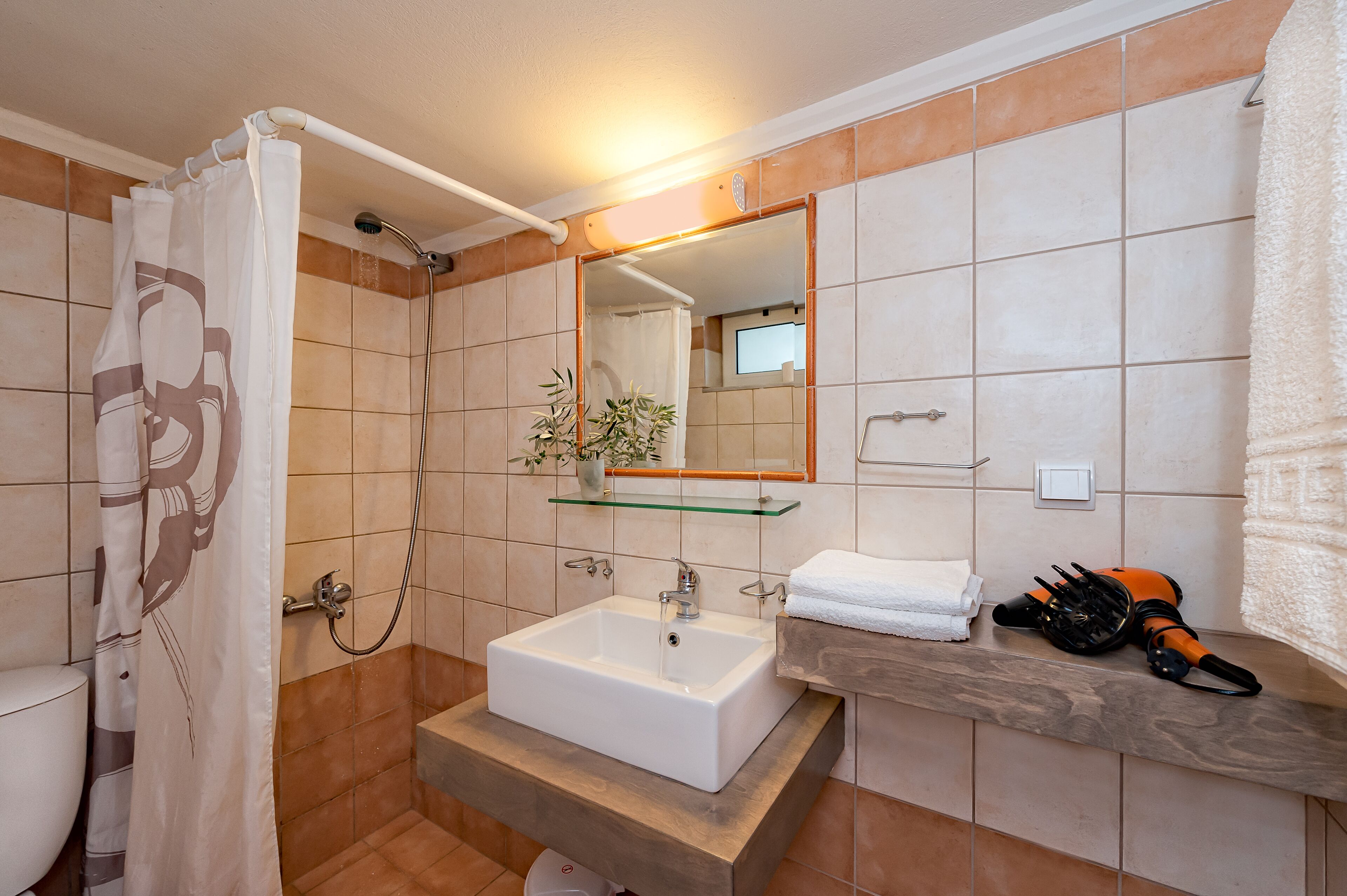 A bathroom with a shower, a sink, a mirror, and a towel rack.