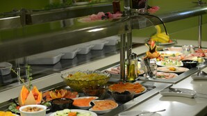 Een buffet met diverse gerechten en een waterdispenser.