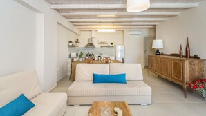 Un soggiorno moderno con un divano, un tavolino da caffè e una cucina sullo sfondo.