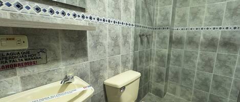 Un baño con lavamanos, inodoro y ducha.