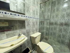 A bathroom with a sink, toilet, and shower.