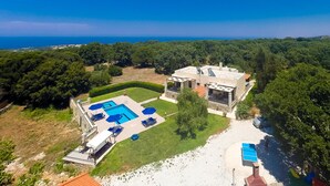 A villa with a swimming pool, a patio area, and a view of the sea. - Modern Countryside Villa with Private pool, spectacular view, peaceful location (Πρινές)