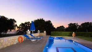 A swimming pool with blue tiles, lounge chairs, and umbrellas. - Modern Countryside Villa with Private pool, spectacular view, peaceful location (Πρινές)