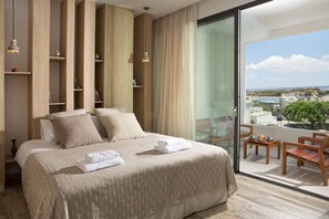Relax in a spacious room with a large bed, shelving unit, and balcony with city views.
