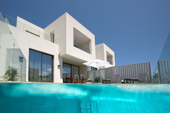 Relax by the pool surrounded by lounge chairs and umbrellas.