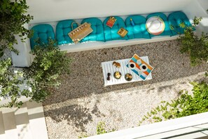 Relax in this serene outdoor seating area with cushioned benches and a selection of decorative items.