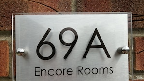A sign for "69A Encore Rooms" mounted on a brick wall. - Encore Rooms (Scunthorpe)